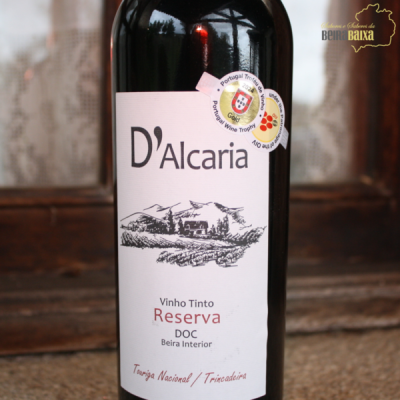 Garrafa de vinho tinto Reserva D'Alcaria com rótulo branco e selos de certificação.
