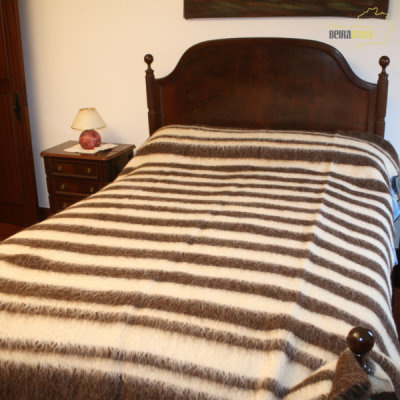 cama de madeira escura com manta riscada castanho e branco