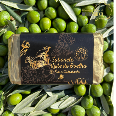 Sabonete Leite de Ovelha extra hidratante em embalagem preta e dourada sobre azeitonas verdes