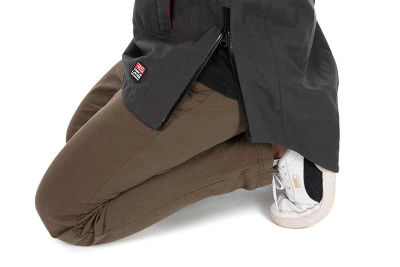 Fox Rage Camo Triple Layer Smock Pernas com calças castanhas e ténis brancos com detalhes dourados e pretos