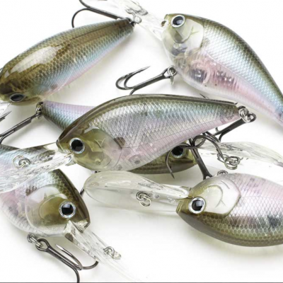 Iscos de pesca artificiais cinza esverdeados com ganchos, sobre fundo branco