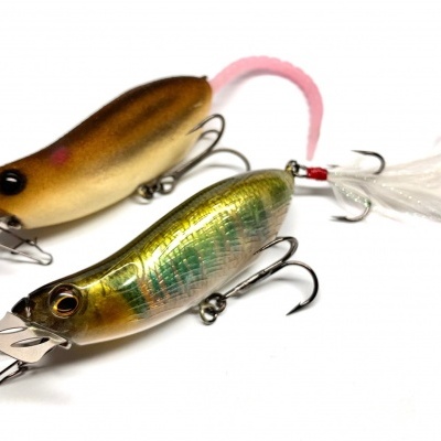 Dois iscos artificiais para pesca castanho e metálico com anzóis e penas