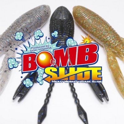 Três iscas artificiais para pesca em cores cinzento, preto e castanho dourado com texturas e múltiplos apêndices, com logo colorido BomB SHOtE no centro.