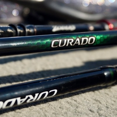 Varas de pesca CURADO com punhos de cortiça sobre superfície cinzenta