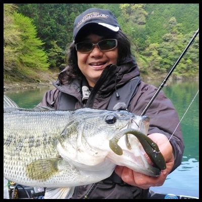 Pessoa segurando peixe grande com isca, em ambiente natural