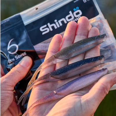 Iscos artificiais Shindo 6.0 cores cinza e azul em mão com embalagem preta ao fundo