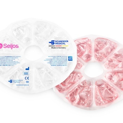 Dois discos circulares de gel para terapia frio/quente, um transparente com texto e outro rosa, com segmentos triangulares e buraco central.