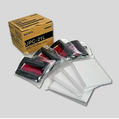 Caixa SONY UPC-21L com cartuchos de impressão vermelhos e pretos e quatro folhas brancas.