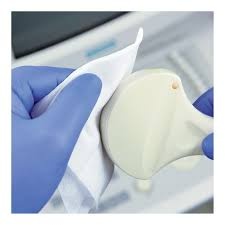 Luva azul segurando dispositivo branco curvo em ambiente de laboratório
