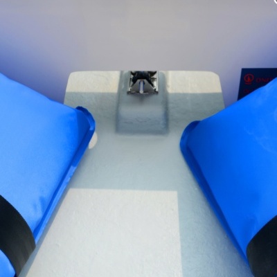 Barco com dois coletes salva-vidas azuis nas laterais e superfície branca