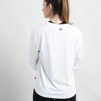 Mulher de costas vestindo t-shirt branca de manga comprida com logo circular nas costas e leggings pretas