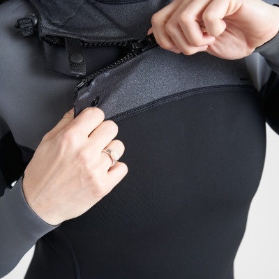 Pessoa a abrir fecho de roupa de neopreno preta e cinza