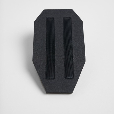 Peça preta com tiras elásticas pretas sobre fundo cinza claro