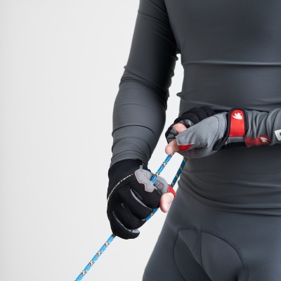 Pessoa de roupa desportiva cinzenta com luvas pretas e cinzentas segurando uma corda azul.