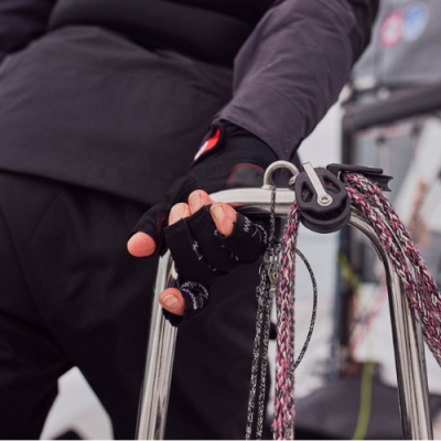 Mão com luva a segurar mastro e cabos de veleiro