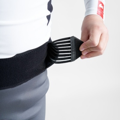 Pessoa a vestir cinto elástico preto com fecho de velcro