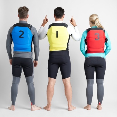 Três pessoas de costas com coletes salva-vidas numerados e roupas de neoprene.