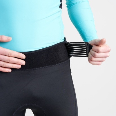 Pessoa a vestir calças justas pretas com parte superior elástica e ajuste elástico listrado brancas e pretas