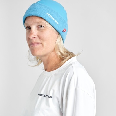 Mulher com gorro azul e t-shirt branca com marca ROOSTER em fundo cinza