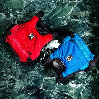 Dois coletes salva-vidas vermelho e azul sobre superfície de pedra verde