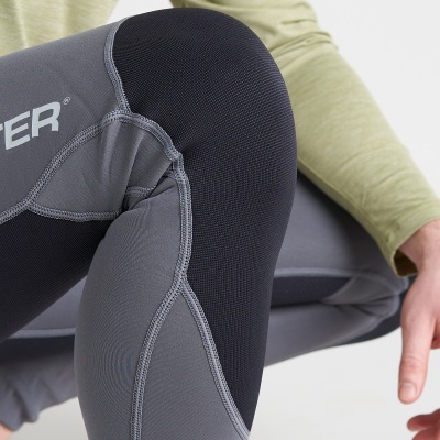 Pessoa com calças desportivas cinza e preto e camisa verde clara