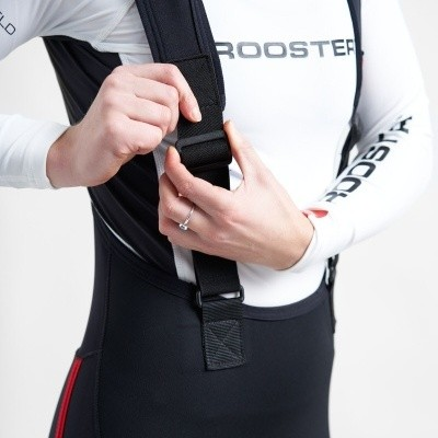 Pessoa ajustando alça de roupa desportiva preta e branca com texto ROOSTER