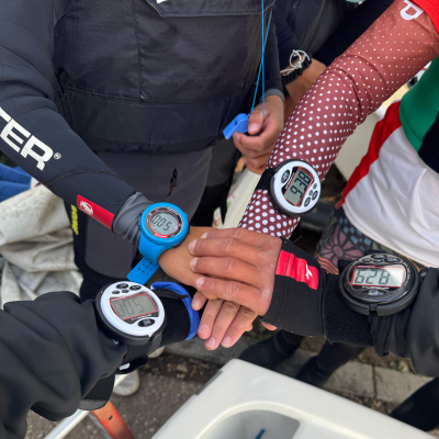 Quatro pessoas com computadores de mergulho digitais nos pulsos exibindo números diferentes