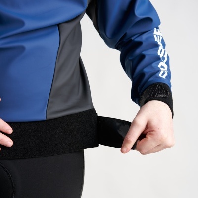 Pessoa a ajustar cinta preta em casaco impermeável azul com painel cinza e texto branco na manga