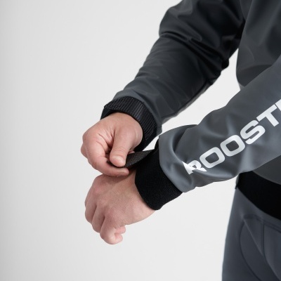 Jaqueta cinza escura com punhos pretos ajustáveis e texto 'ROOSTER' na manga direita.