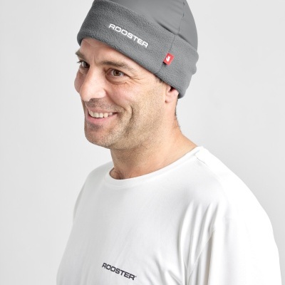 Homem com gorro cinzento e t-shirt branca, ambos com texto ROOSTER.