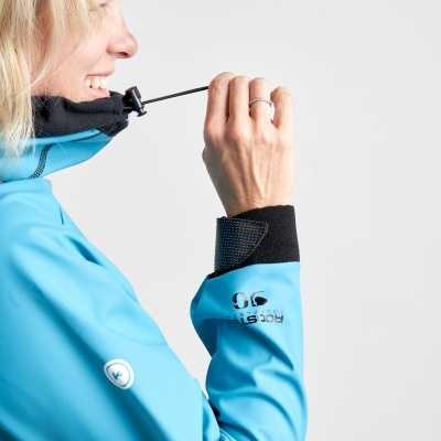 Casaco azul claro com capuz e punhos pretos, detalhe de cordão ajustável e inscrições no braço