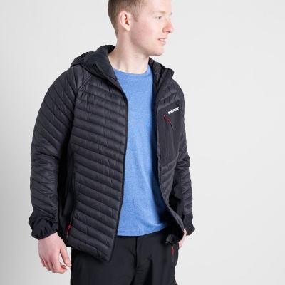 homem com casaco acolchoado preto, camiseta azul e calças pretas