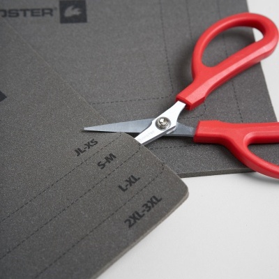 tesoura vermelha sobre cartão cinza com marcas de tamanhos