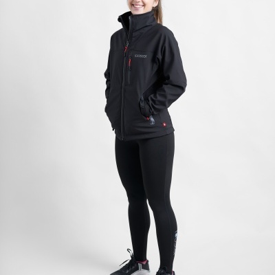 Mulher com casaco preto ECOGEAR, calças pretas e ténis em fundo branco