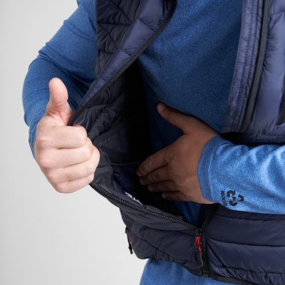 Pessoa com camisola azul e colete acolchoado azul escuro aberto