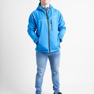 Homem com casaco azul, jeans claros, sapatilhas pretas e gorro azul escuro em fundo branco