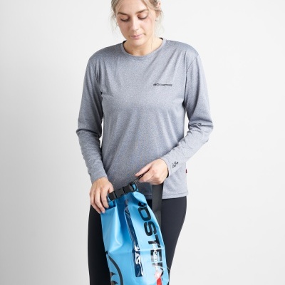 Mulher com camisa cinza e calças pretas segurando sacola azul impermeável