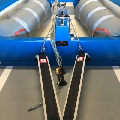 barco insuflável azul com flutuadores cinza e detalhes vermelhos em espaço fechado