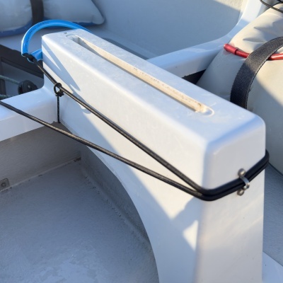 Embarcação branca com faixa azul e cordas pretas