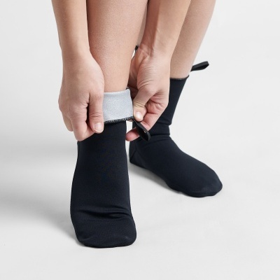 Meias pretas com interior cinzento sendo ajustadas por uma pessoa