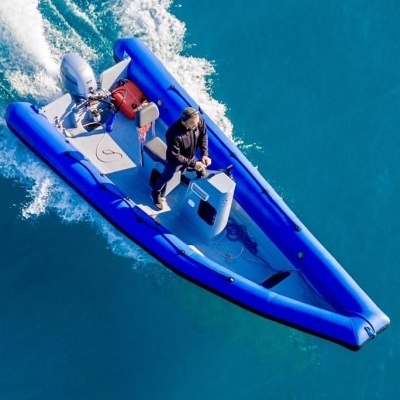 Bote insuflável azul com motor de popa em mar calmo