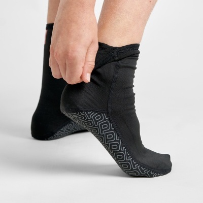 Meias pretas com sola antiderrapante e padrão geométrico cinza usadas por uma pessoa