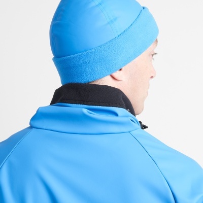 Gorro azul com textura suave e tecido liso usado por pessoa de costas com roupa azul e detalhes pretos