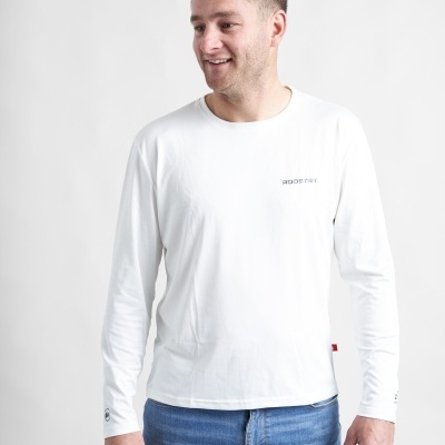 Homem com t-shirt branca de manga comprida e jeans azuis em fundo branco