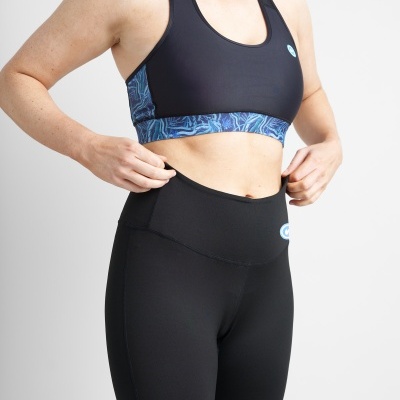 Conjunto de roupa desportiva com top preto e leggings pretas em fundo branco