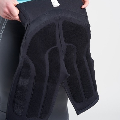 Equipamento desportivo preto com acolchoamento e textura, segurado por uma pessoa