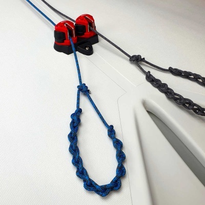 Duas cordas trançadas azuis e pretas com suporte vermelho e preto em superfície branca