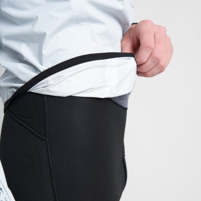 Pessoa vestindo calças justas negras com detalhe branco na cintura e parte superior branca