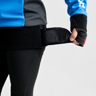 Roupa desportiva azul e preta com velcro preto sendo ajustado por mão com luva preta