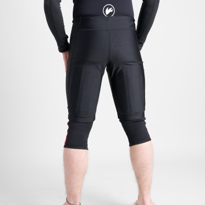 Pessoa de costas vestindo calças justas pretas até ao joelho com cortes visíveis e camisola preta com logotipo branco na parte inferior das costas